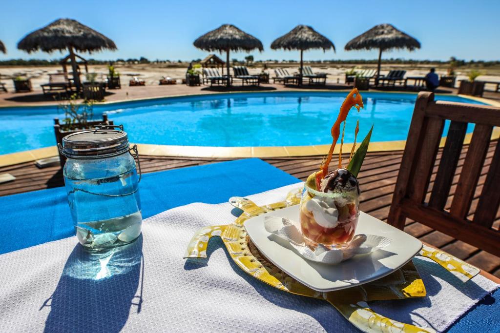 a drink on a table next to a swimming pool at CAP KIMONY in Morondava