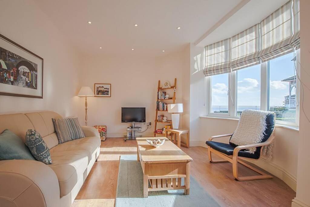 uma sala de estar com um sofá e uma televisão em Carlton Lodge: Stunning two bedroom apartment em Broadstairs