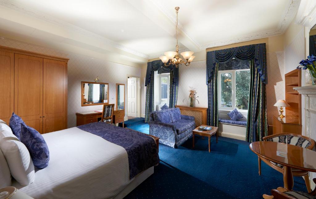 une chambre d'hôtel avec un lit, une table et des chaises dans l'établissement Les Rocquettes Hotel, à Saint-Pierre-Port