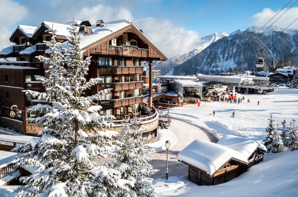 un lodge de ski dans les montagnes avec de la neige au sol dans l'établissement Hôtel de la Loze, à Courchevel