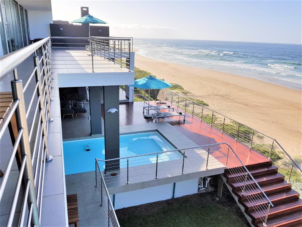 a house with a swimming pool and a beach at MGM Wilderness in Wilderness