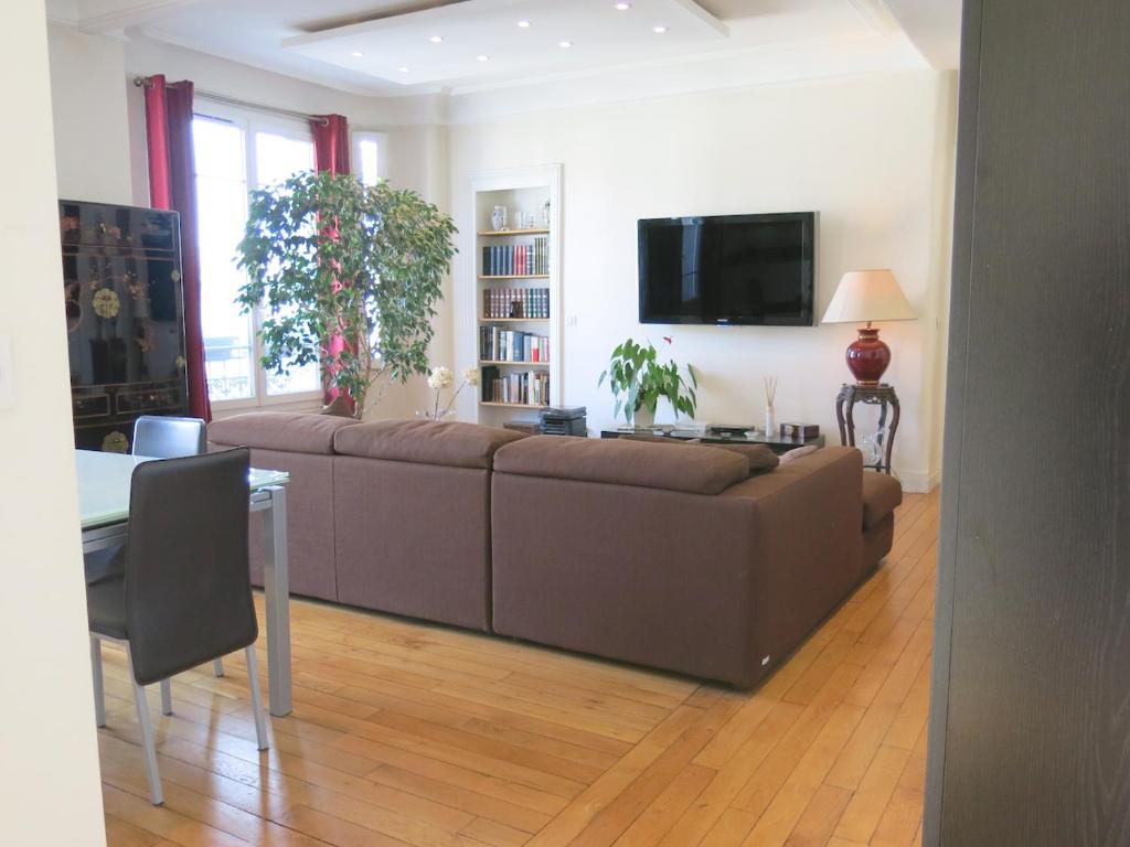 sala de estar con sofá marrón y mesa en Appartement Les Lilas très proche métro CityCosy, en Les Lilas