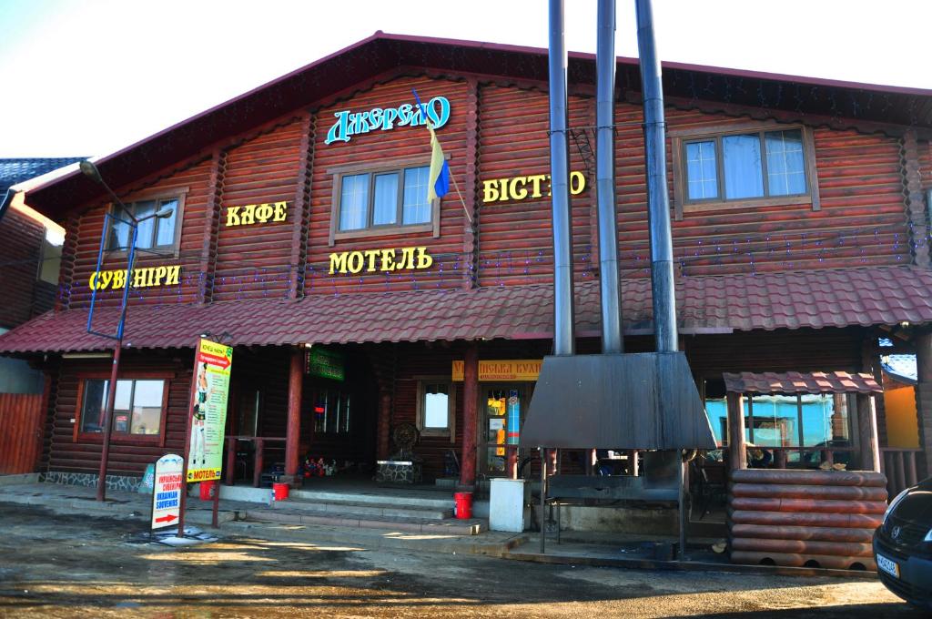 a wooden building with a sign on the front of it at Джерело in Brody