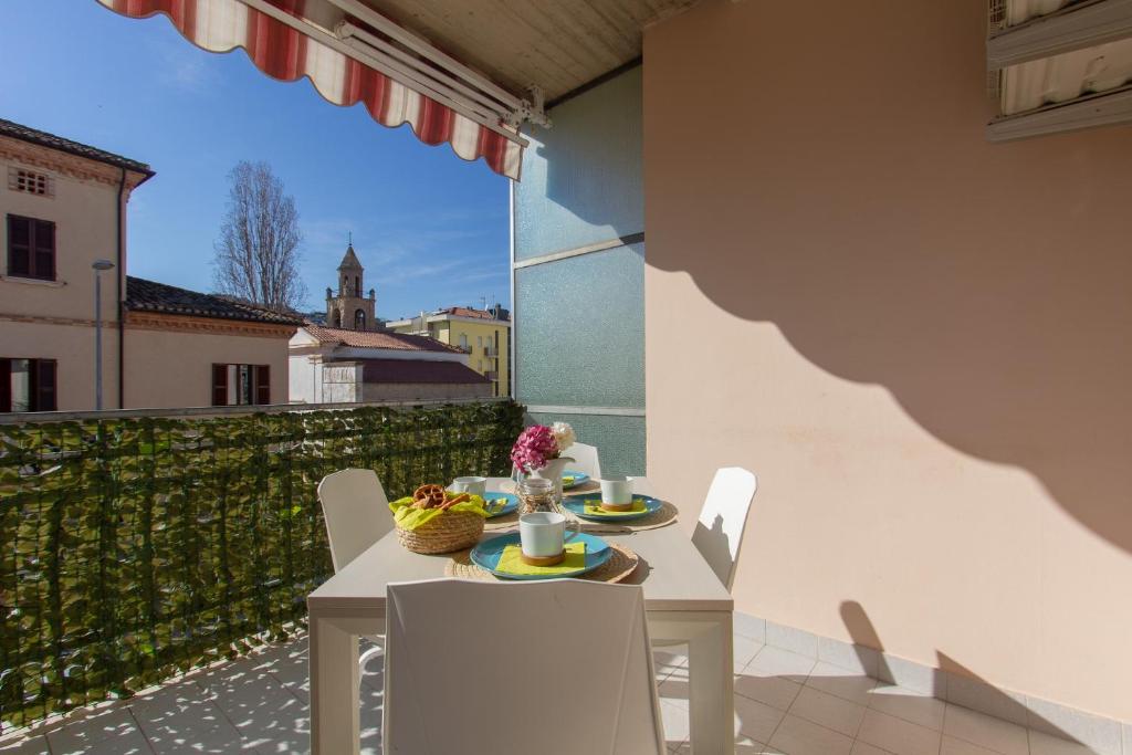 uma mesa e cadeiras numa varanda com vista em Appartamento Galileo - MyHo Casa em Tortoreto Lido
