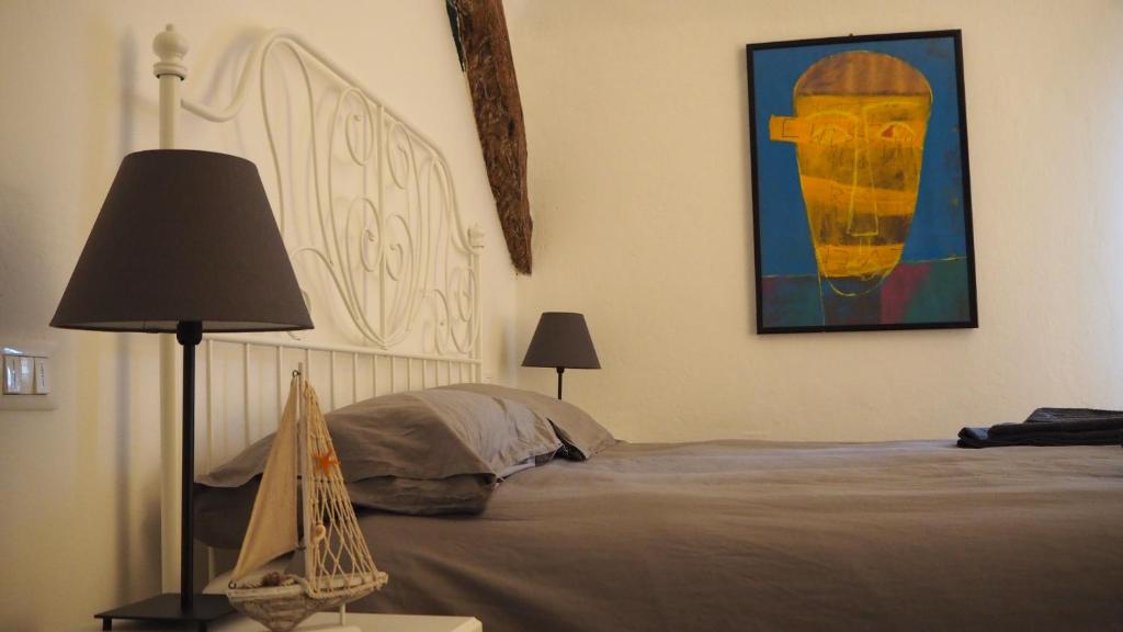 1 dormitorio con 1 cama y una pintura en la pared en Q.B. Osteria, en Albisola Superiore