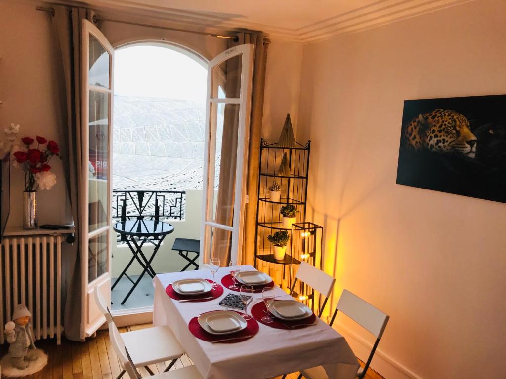 a dining room with a table and chairs and a window at Paris My 16ème in Boulogne-Billancourt