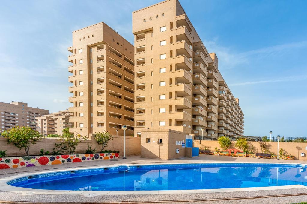 a swimming pool in front of two tall buildings at Vacaciones Oromarina Jardines del Mar in Oropesa del Mar