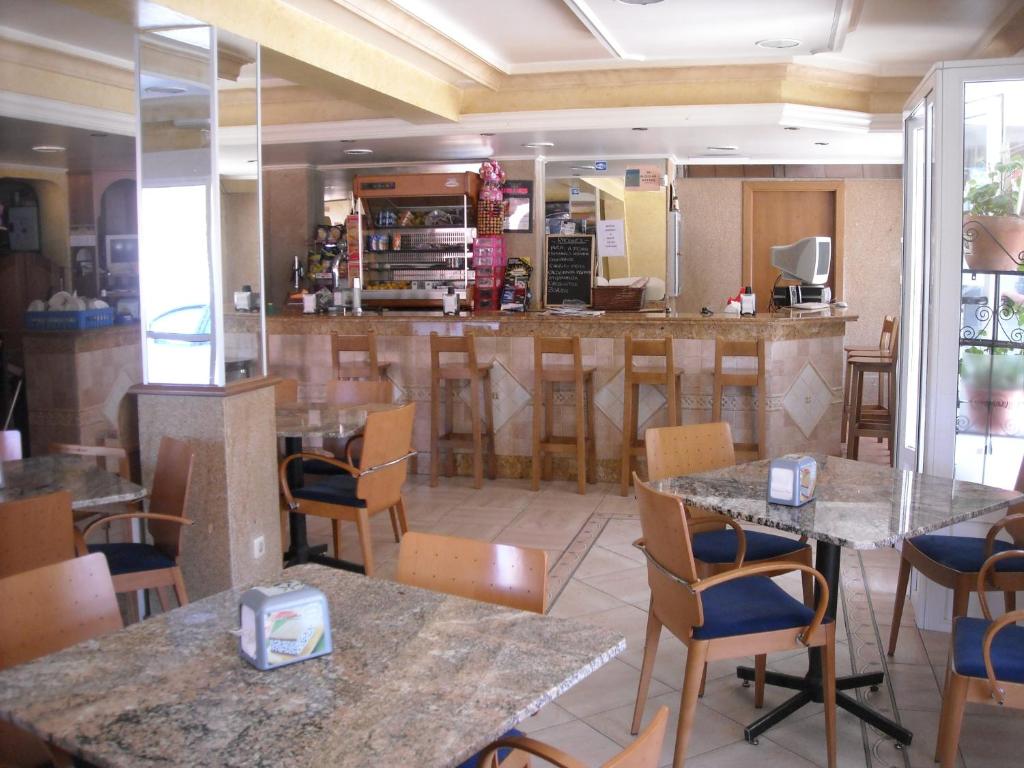 希奧的住宿－Hospedaje O Canizo，一间带桌椅的餐厅和一间酒吧