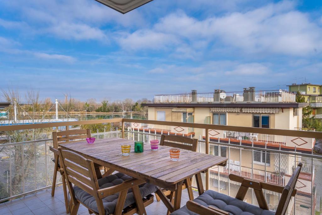une table et des chaises en bois sur un balcon dans l'établissement Casa di Annika - Vista Laguna e Parcheggio privato, à Grado