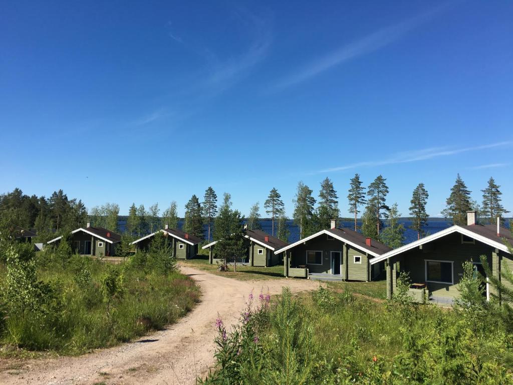 une rangée de cottages sur un chemin de terre dans l'établissement Lomamökit Saimaanranta Suur-Saimaa Strand Resort Oy, à Taipalsaari