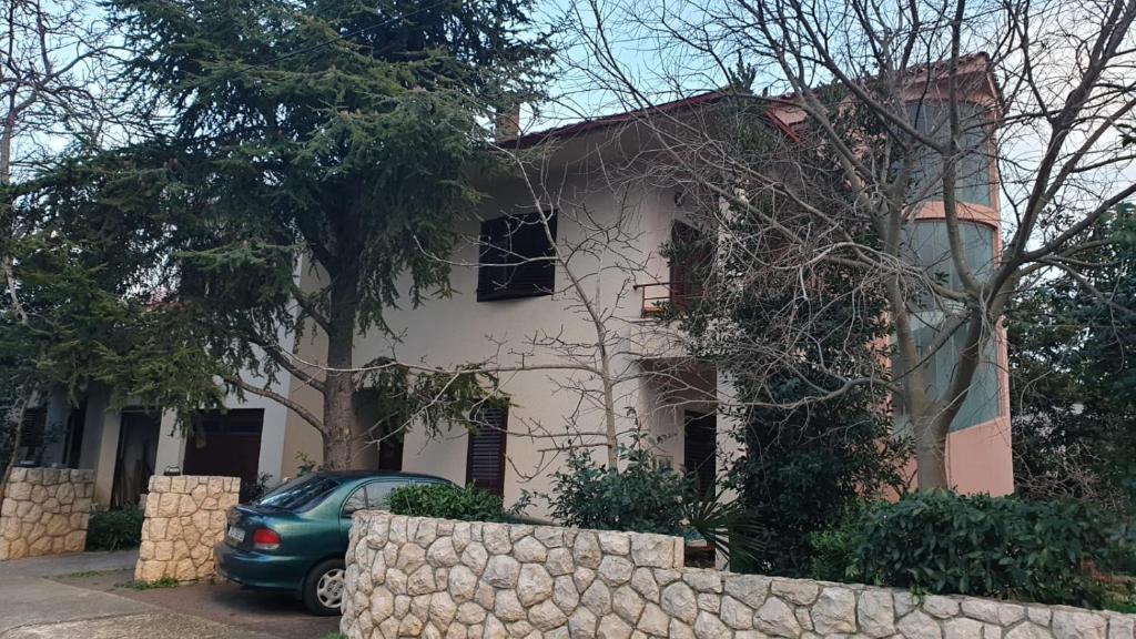 a house with a car parked in front of it at Apartment Len Slovaci in Zadar