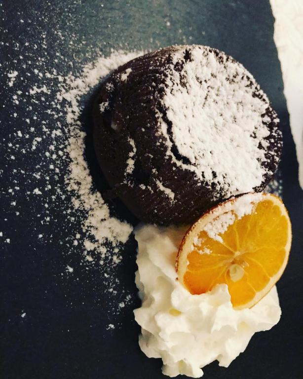 a chocolate dessert with an orange slice on top at Masseria Valente in Ostuni