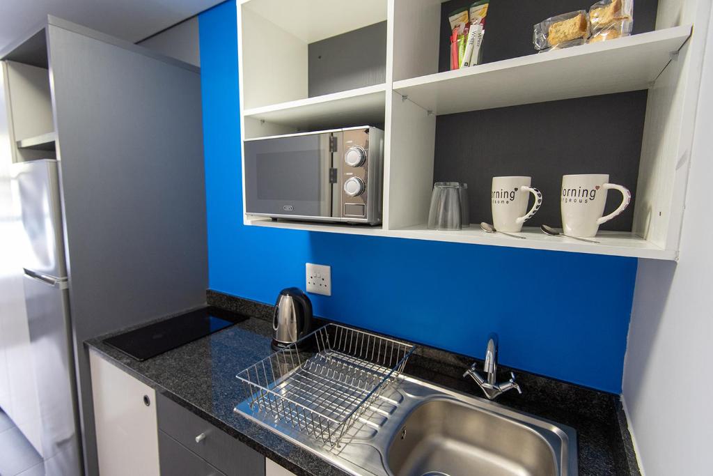 a kitchen with a sink and a microwave at CampusKey Cape Town in Cape Town