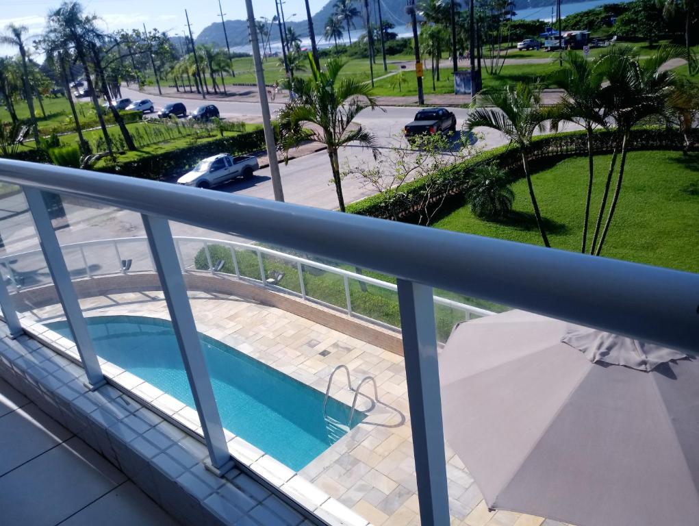 a balcony with a swimming pool and a parking lot at Reserva Dell Mar in Bertioga