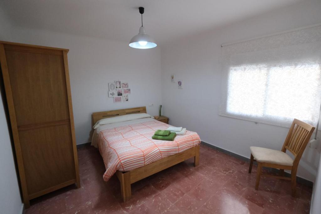 ein Schlafzimmer mit einem Bett, einem Stuhl und einem Fenster in der Unterkunft Apartament Tarracoliva in Tarragona