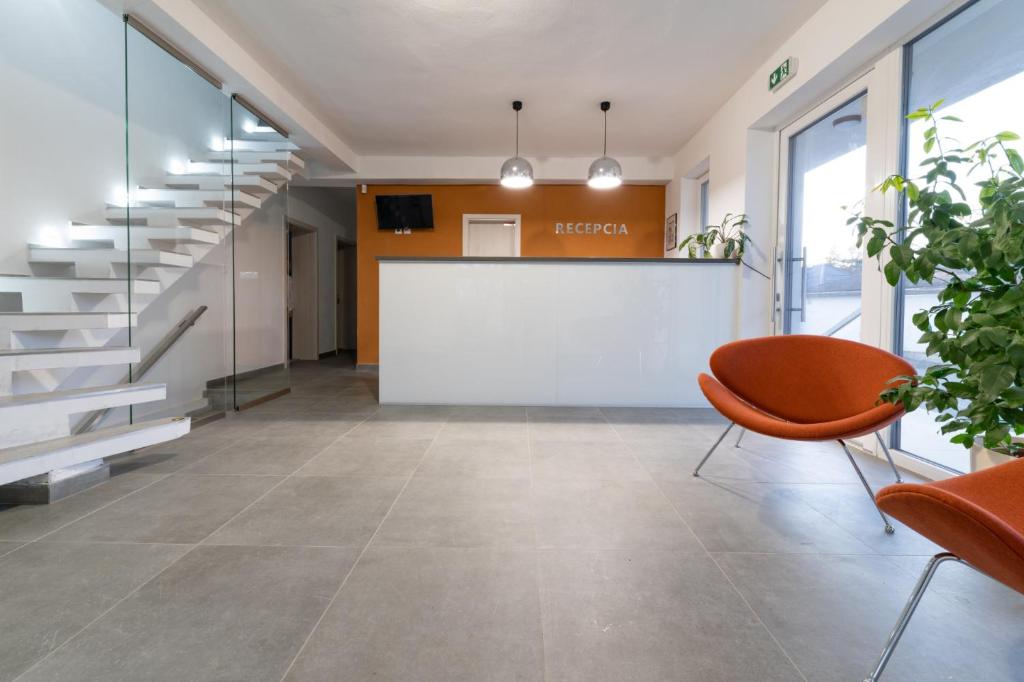 an office lobby with a whiteboard and orange chair at Penzión pod brezami** in Nitra