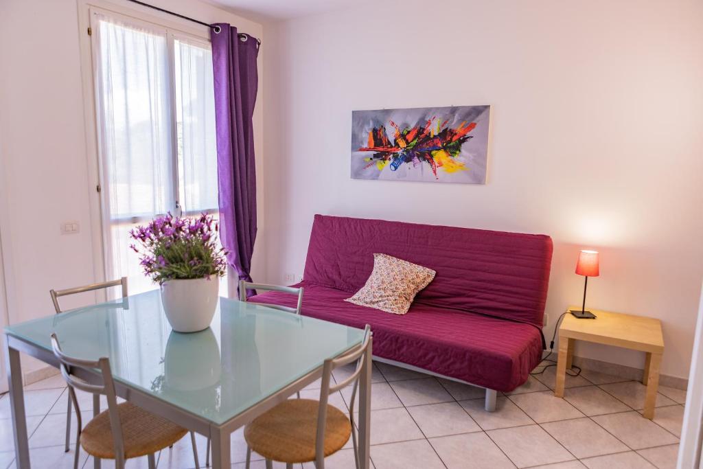 a living room with a purple couch and a glass table at Baia Blu RTA Residence in Lerici