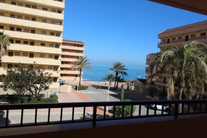 uma varanda com vista para uma praia e edifícios em Przytulny Apartament z widokiem na morze !!!!! em La Mata