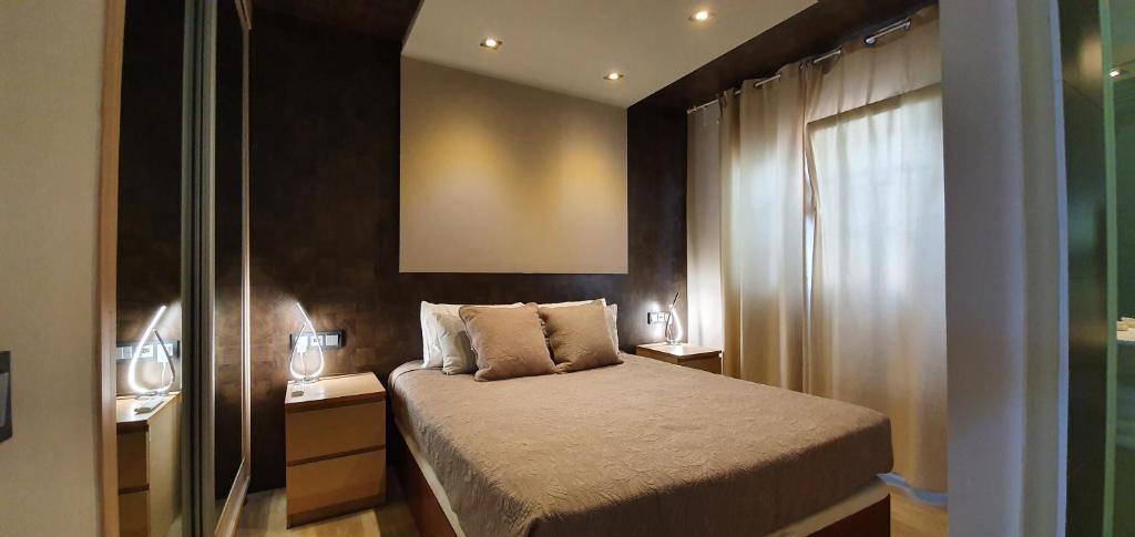 um pequeno quarto com uma cama e uma janela em Villa Adler Gay Men Only em Playa del Inglés