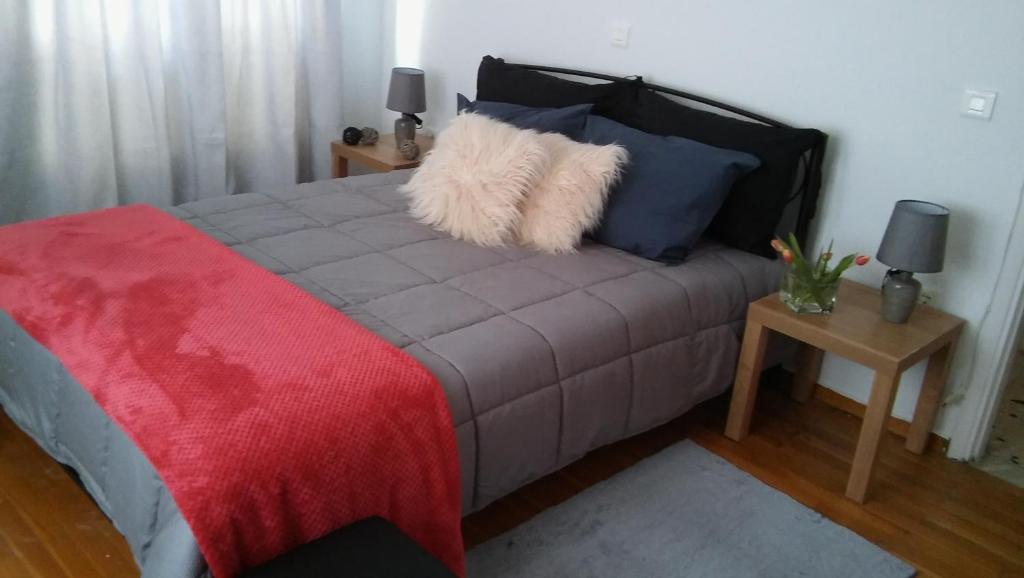 um quarto com uma cama com um cobertor vermelho em Central Location em Nafplio