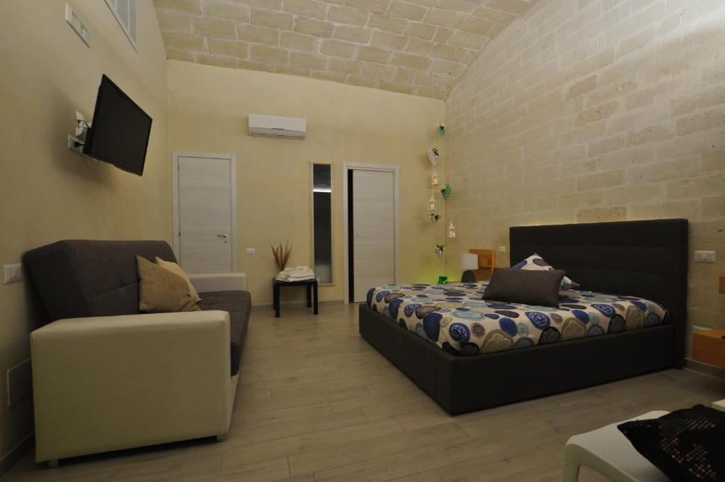 a bedroom with a bed and a couch and a chair at Le dimore della Luna in Matera