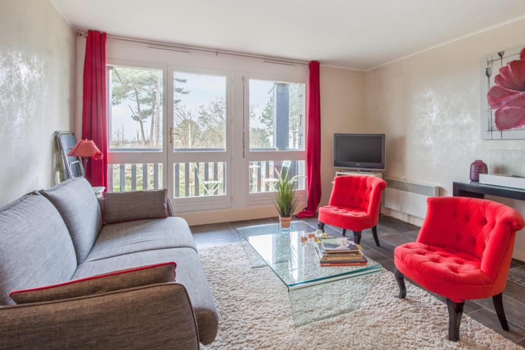濱海圖維列的住宿－Charming and calm flat with balcony and parking in Trouville - Welkeys，客厅配有沙发和2把红色椅子