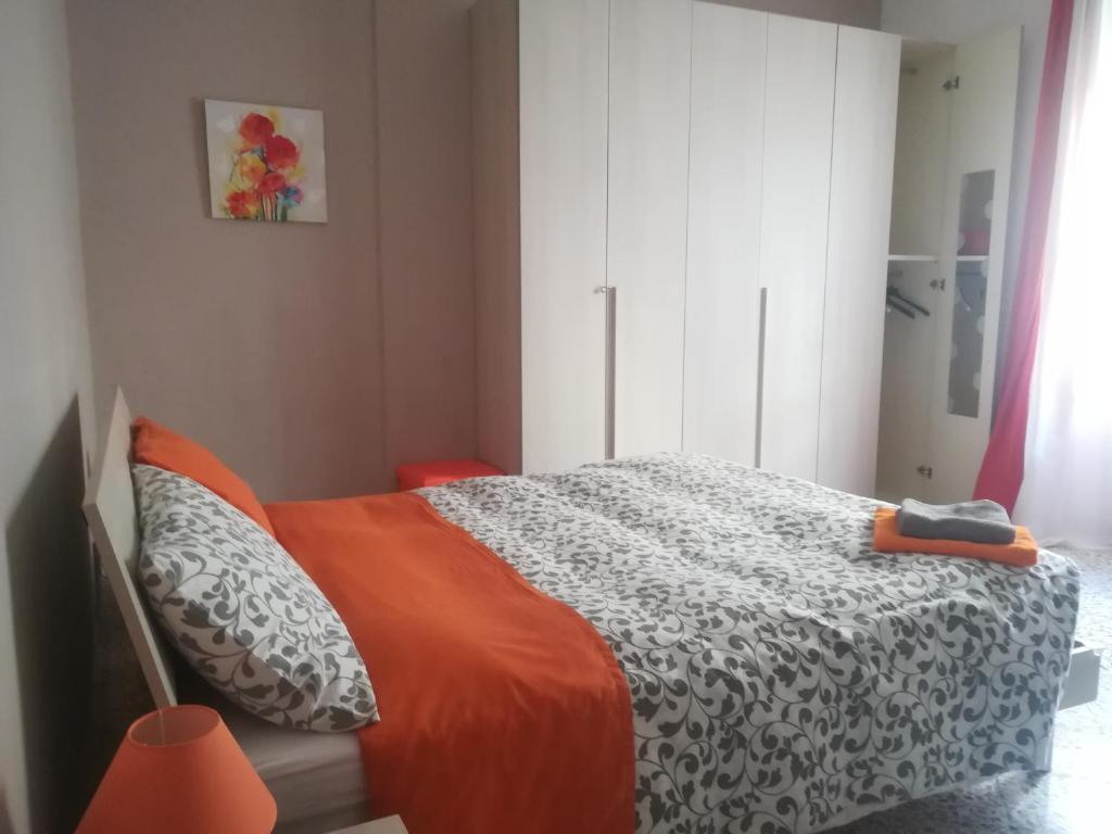 a bedroom with a bed with an orange blanket at B&B Metro Salerno in Salerno