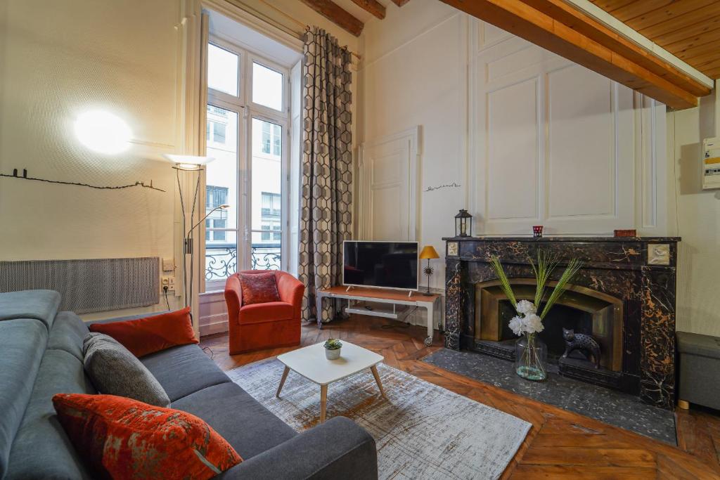 sala de estar con sofá y chimenea en DIFY Petit Prince - Place Bellecour, en Lyon