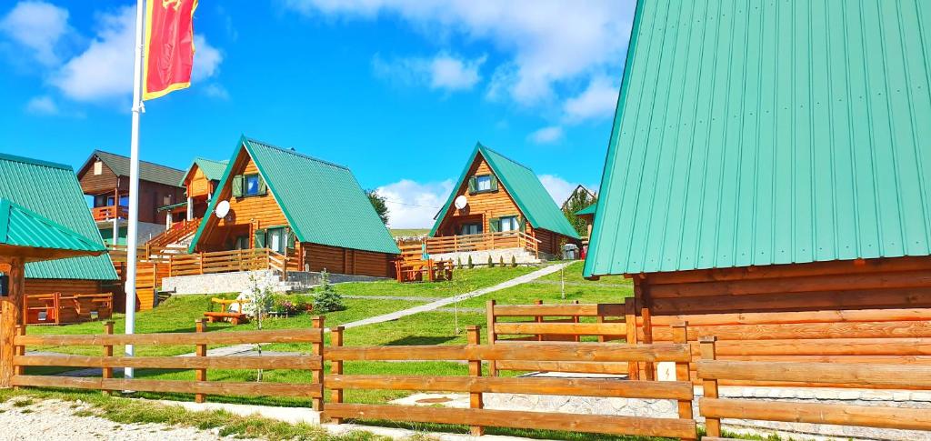 a row of wooden homes with green roofs at Woodland in Žabljak