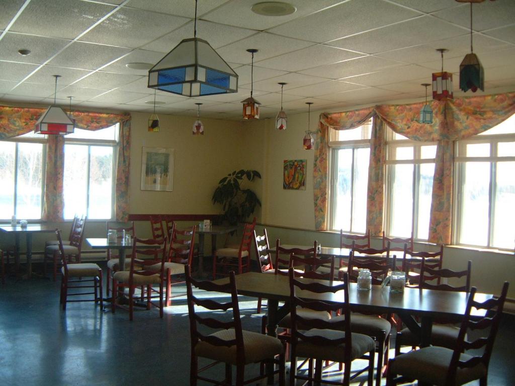 Auberge Île du Repos في هونفلور: غرفة طعام مع طاولات وكراسي ونوافذ