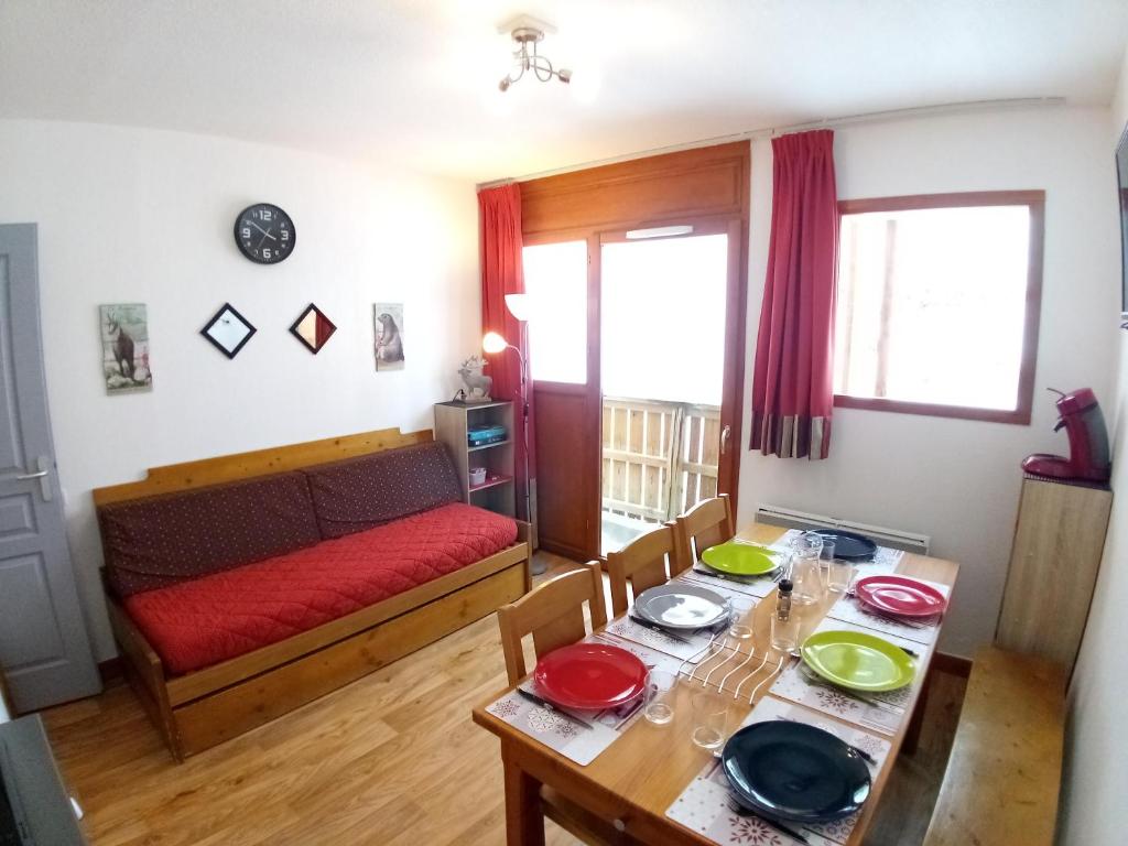 ein Wohnzimmer mit einem Tisch und einem Sofa in der Unterkunft Au bon endroit N1 - Appartement 2 pièces 7 personnes - proche pistes - coeur station - balcon in Orcières