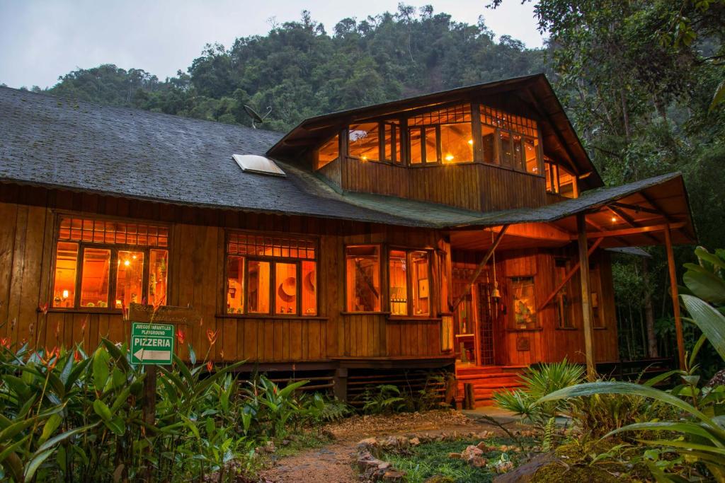 una gran casa de madera con muchas ventanas en Mindo Garden Lodge and Wildlife Reserve en Mindo