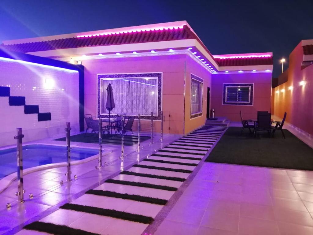 a house with a swimming pool at night at Abo Naif Resort in Rayyis