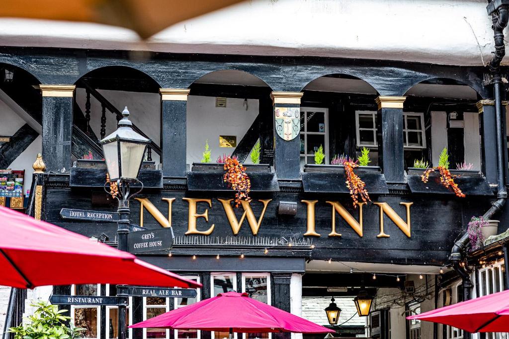 una nueva señal de posada en el lado de un edificio en The New Inn en Gloucester