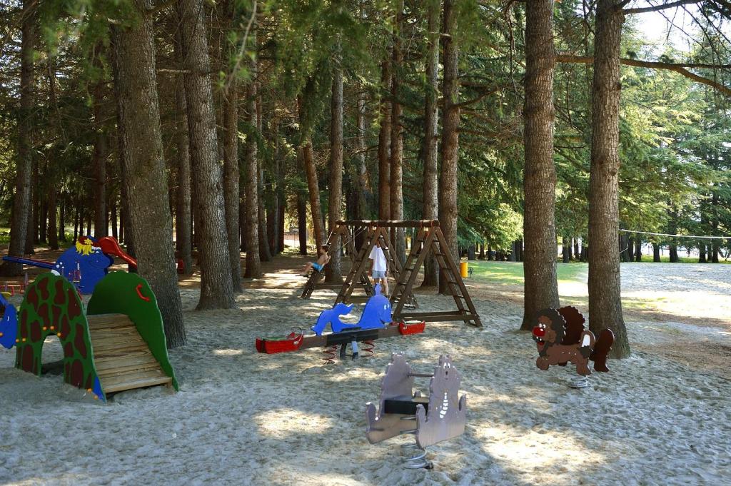 a playground with play equipment in a park with trees at Hotel Mediteran Plava Laguna in Poreč