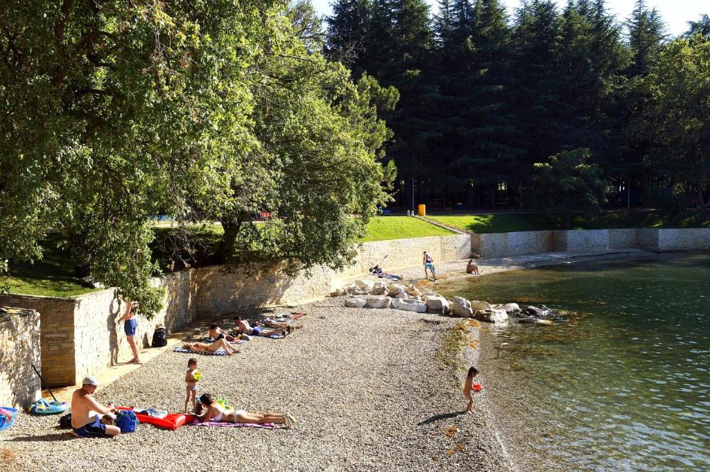 a group of people laying on the shore of a river at Hotel Mediteran Plava Laguna in Poreč