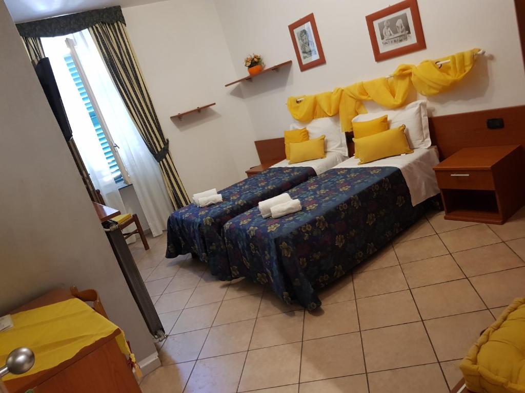 um quarto com 2 camas e almofadas amarelas em Cavallo Bianco em Novara