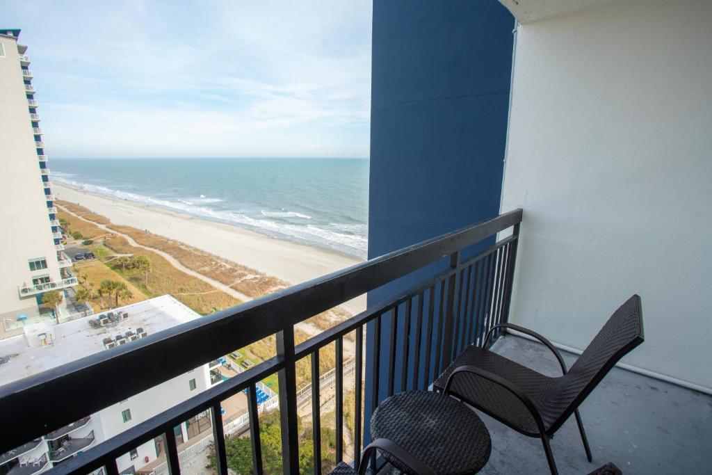 a balcony with a chair and a view of the beach at Sun N Sand Resort in Myrtle Beach