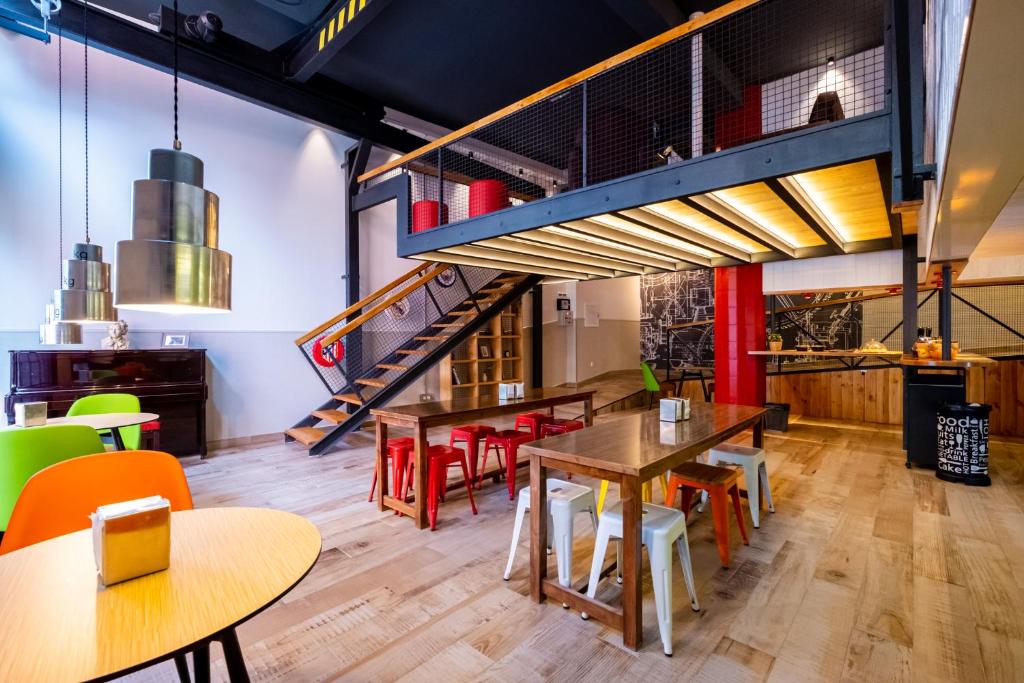 un restaurante con mesas y sillas y una escalera en Far Home Bernabeu, en Madrid