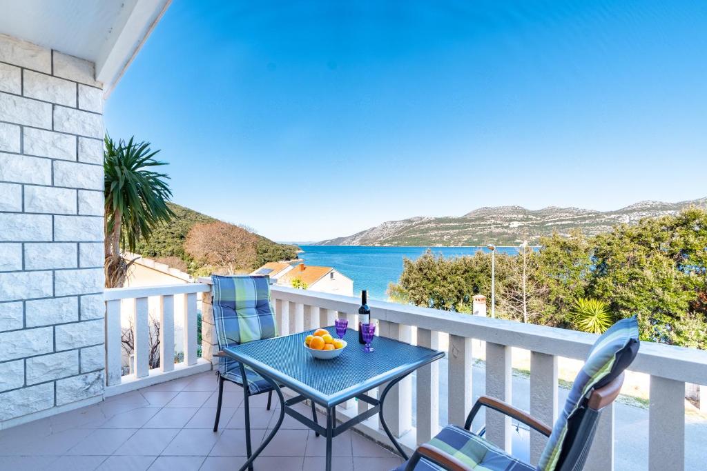 d'une table et de chaises sur un balcon avec vue sur l'océan. dans l'établissement Apartments Tri Žala, à Korčula