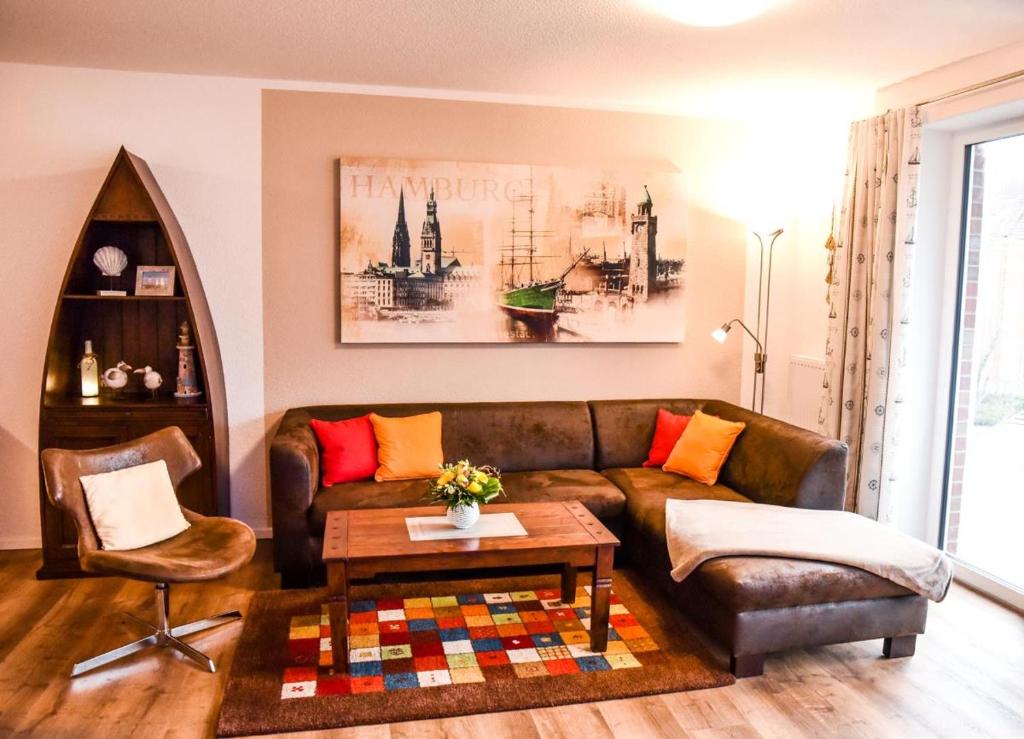 a living room with a brown leather couch and a table at Appartement Abendsonne in Büsum