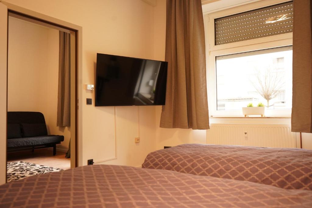 a bedroom with a bed and a television on the wall at Vivo Apartments at Hospitals in Herne