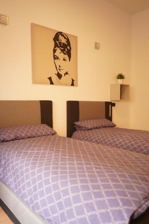 a bedroom with two beds and a picture on the wall at Vivo Apartments at Hospitals in Herne