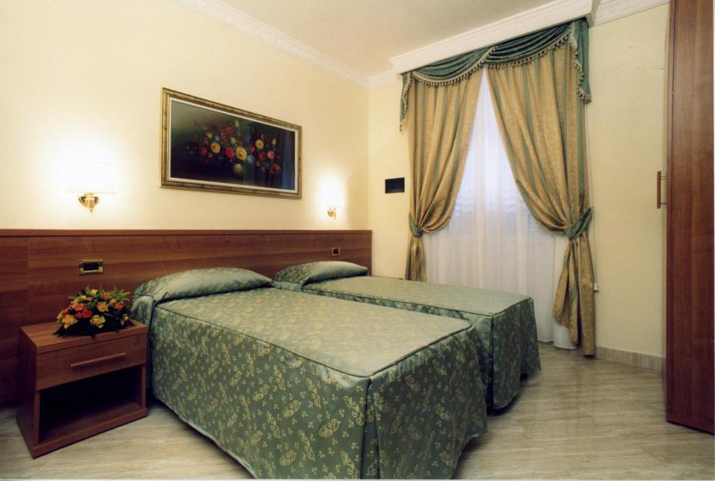a hotel room with two beds and a window at Hotel Magic in Rome
