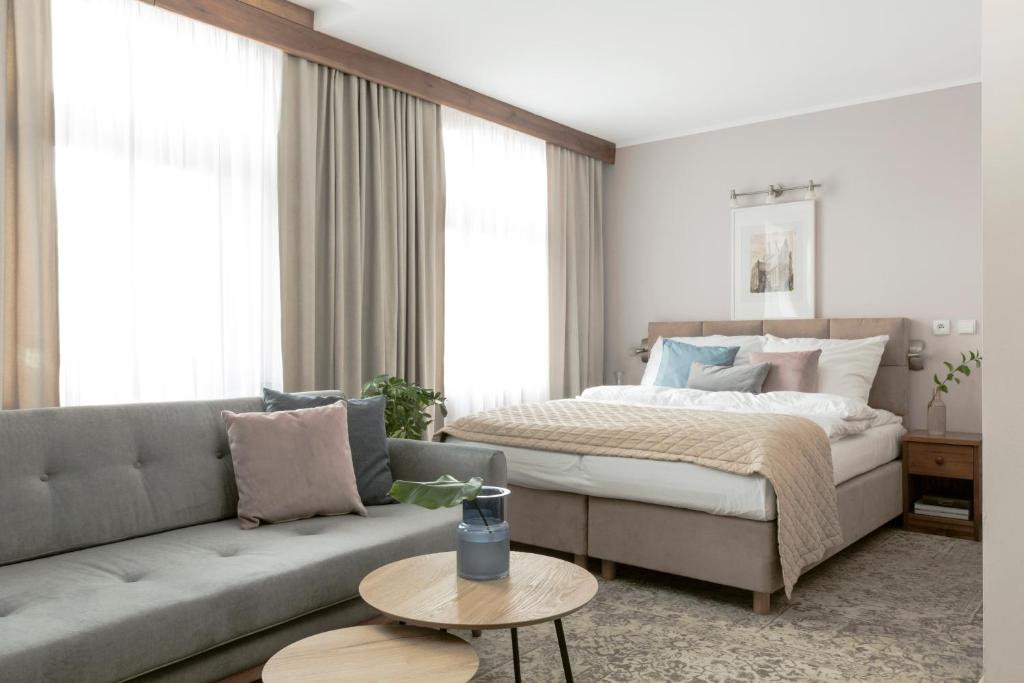 a living room with a bed and a couch at Hotel Karczma Chełmińska in Chełmno