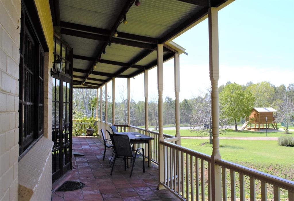 a patio with a table and chairs on a porch at Woolshed Hill Estate in Pokolbin