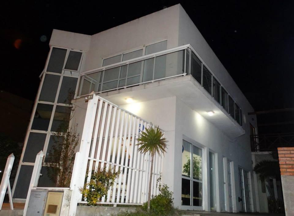 a large white building with a porch and a plant at BRISAS DEL MAR in Santa Teresita