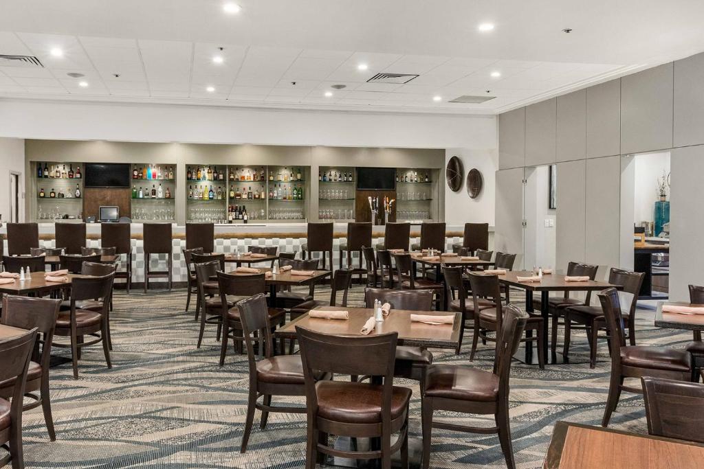 カルガリーにあるBest Western Premier Calgary Plaza Hotel & Conference Centreのテーブルと椅子のあるダイニングルーム