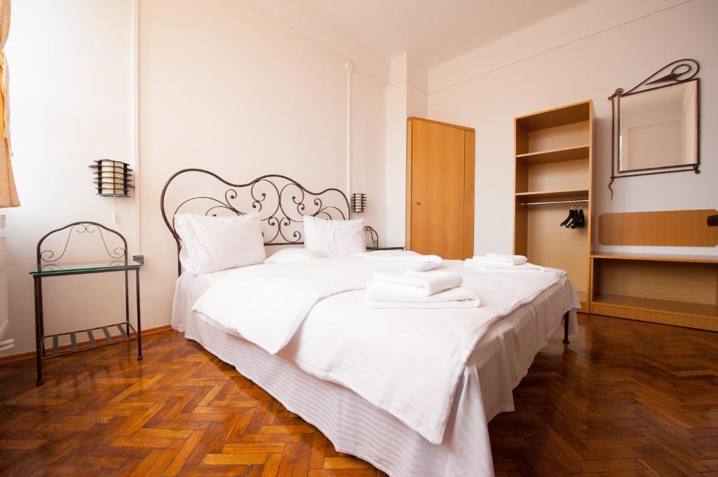 een slaapkamer met een groot wit bed met witte lakens bij Pensiunea Tranzit in Satu Mare