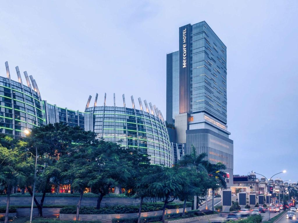 a group of tall buildings in a city with trees at Mercure Jakarta Pantai Indah Kapuk in Jakarta